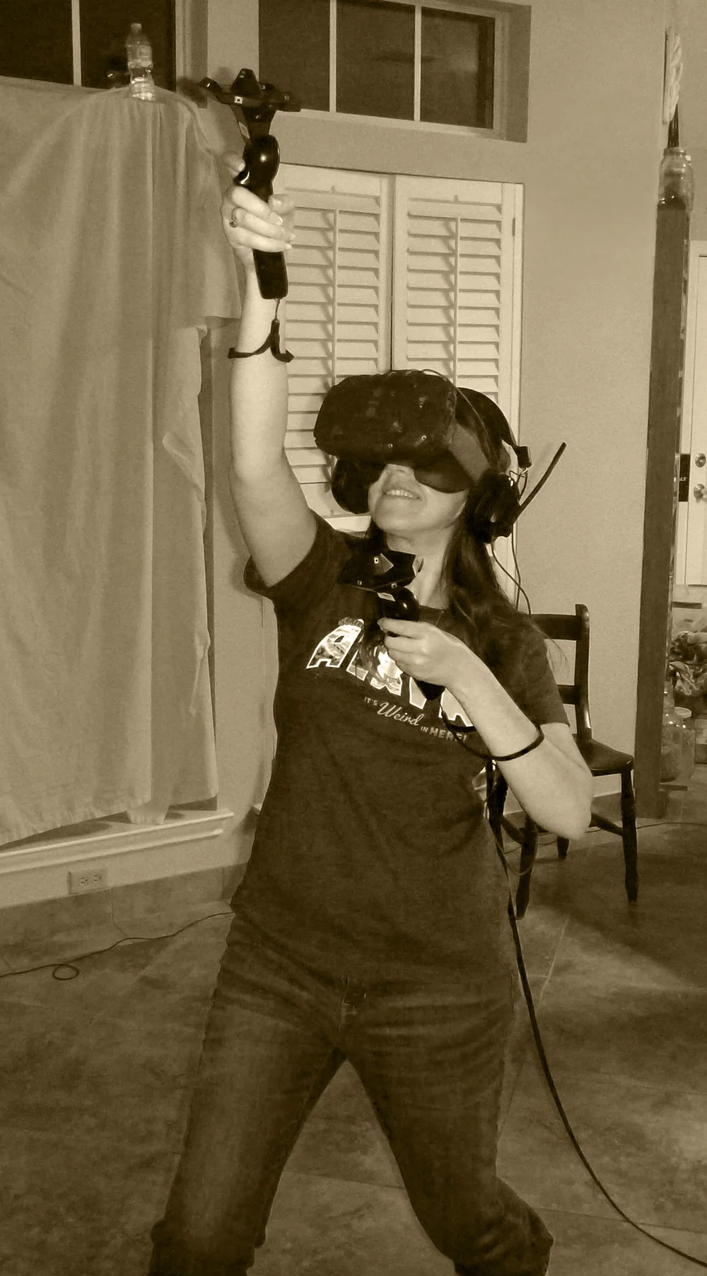 Stephanie Traska wearing a Vive development headset and holding tracked controllers